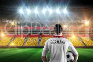 Composite image of germany football player holding ball