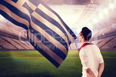 Composite image of handsome football fan looking ahead