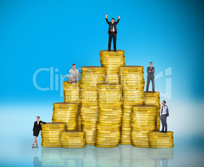 Composite image of business people on pile of coins