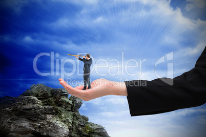 Composite image of businessman looking through telescope in hand