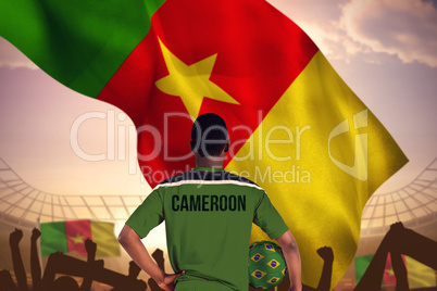 Composite image of cameroon football player holding ball