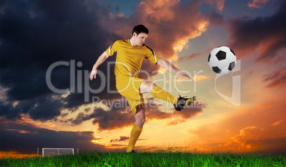 Composite image of football player in yellow kicking