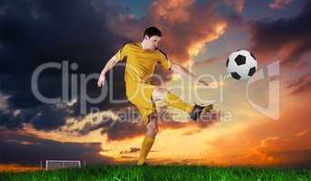 Composite image of football player in yellow kicking