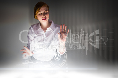 Composite image of redhead businesswoman using interactive desk