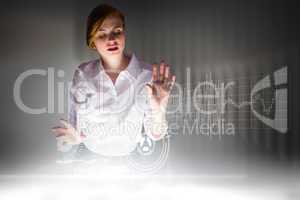 Composite image of redhead businesswoman using interactive desk