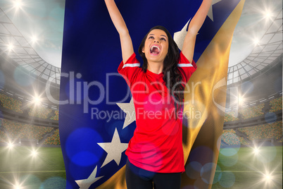 Composite image of cheering football fan in red holding bosnian