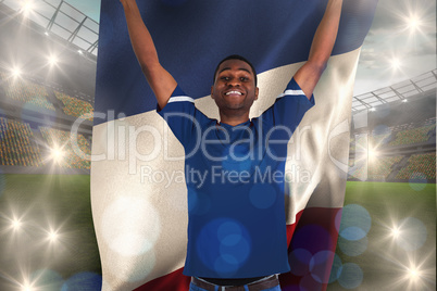 Composite image of cheering football fan in blue jersey holding