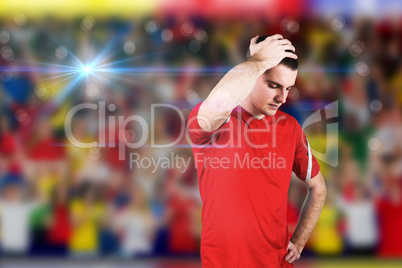 Composite image of disappointed football player looking down