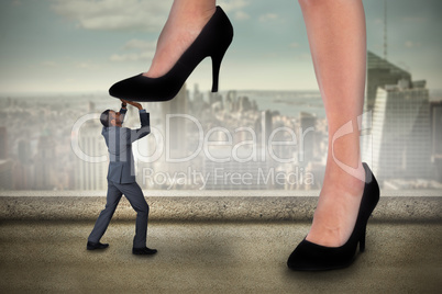 Composite image of businesswoman stepping on tiny businessman