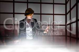 Composite image of redhead businesswoman using interactive desk