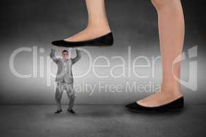 Composite image of businesswoman stepping on tiny businessman