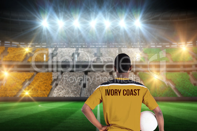 Composite image of ivory coast football player holding ball