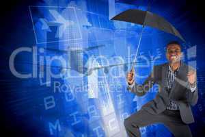 Composite image of businessman cheering and holding umbrella