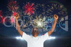 Composite image of excited handsome football fan cheering