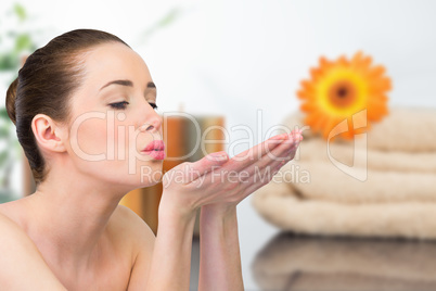 Composite image of beautiful brunette blowing over hands
