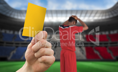 Composite image of hand holding up yellow card