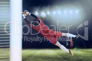 Composite image of goalkeeper in red jumping up