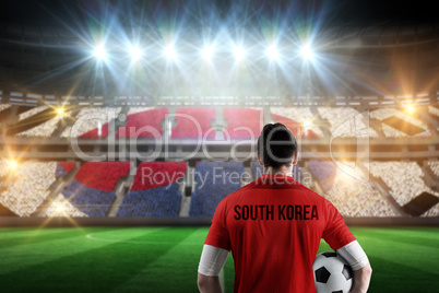 Composite image of south korea football player holding ball