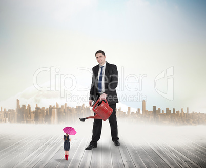 Composite image of businessman watering tiny businesswoman