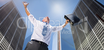 Composite image of businessman holding briefcase and cheering