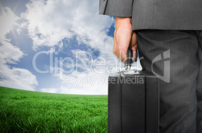 Composite image of businessman holding briefcase