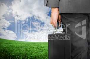 Composite image of businessman holding briefcase