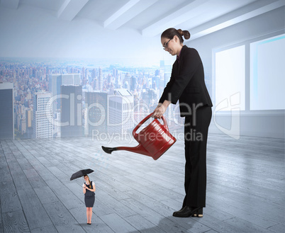 Composite image of businesswoman watering tiny businesswoman