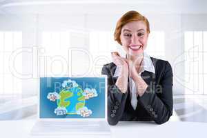 Composite image of excited redhead businesswoman sitting at desk