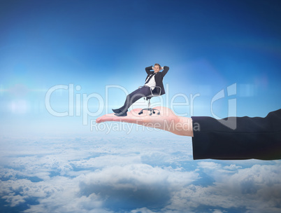 Composite image of businessman relaxing in swivel chair