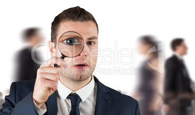 Composite image of businessman looking through magnifying glass Composite image of businessman looking through magnifying glass