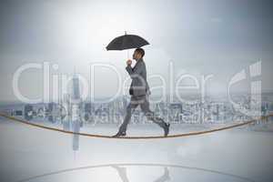 Composite image of businessman walking and holding umbrella on t