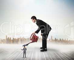 Composite image of businessman watering tiny business team