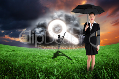 Composite image of young businesswoman holding umbrella