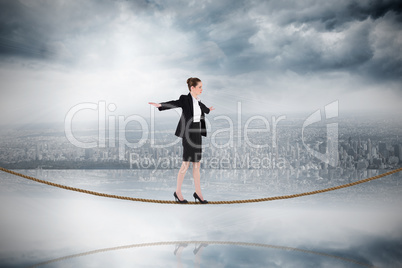 Composite image of businesswoman performing a balancing act on t