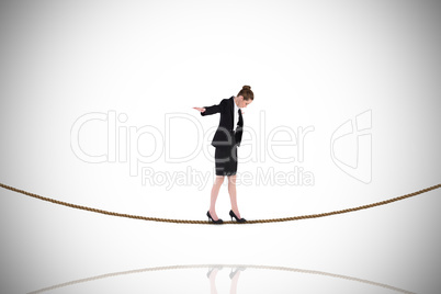 Composite image of businesswoman performing a balancing act on t