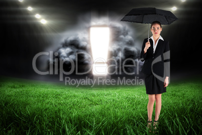 Composite image of young businesswoman holding umbrella