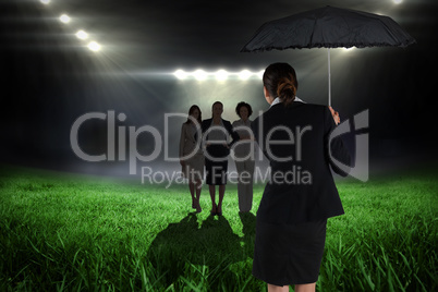 Composite image of young businesswoman holding umbrella