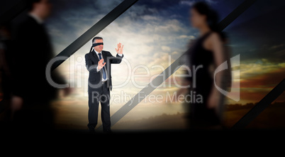 Composite image of mature businessman in a blindfold