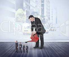 Composite image of mature businessman watering tiny businessman