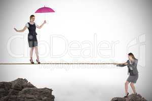 Young business woman pulling a tightrope for businesswoman