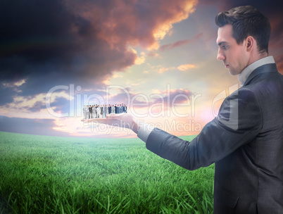 Composite image of businessman holding business team