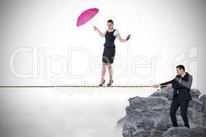 Young businessman pulling a tightrope for businesswoman