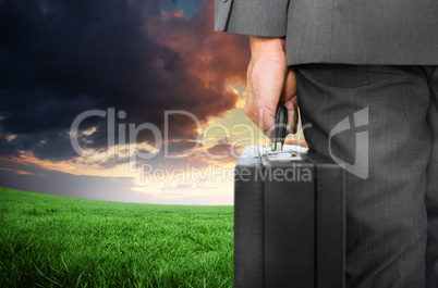 Composite image of businessman holding briefcase