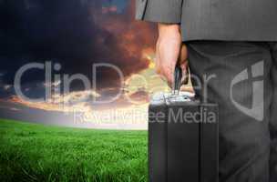 Composite image of businessman holding briefcase