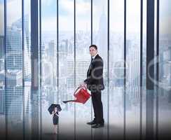 Composite image of businessman watering tiny businesswoman