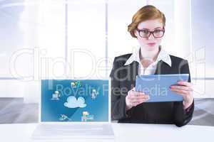 Composite image of redhead businesswoman using her tablet pc