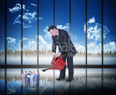 Composite image of mature businessman watering tiny business tea