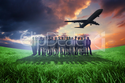 Composite image of business people standing up with airplane