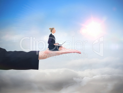 Composite image of businesswoman using laptop