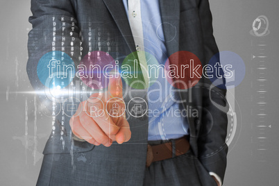 Businessman touching the words financial markets on interface